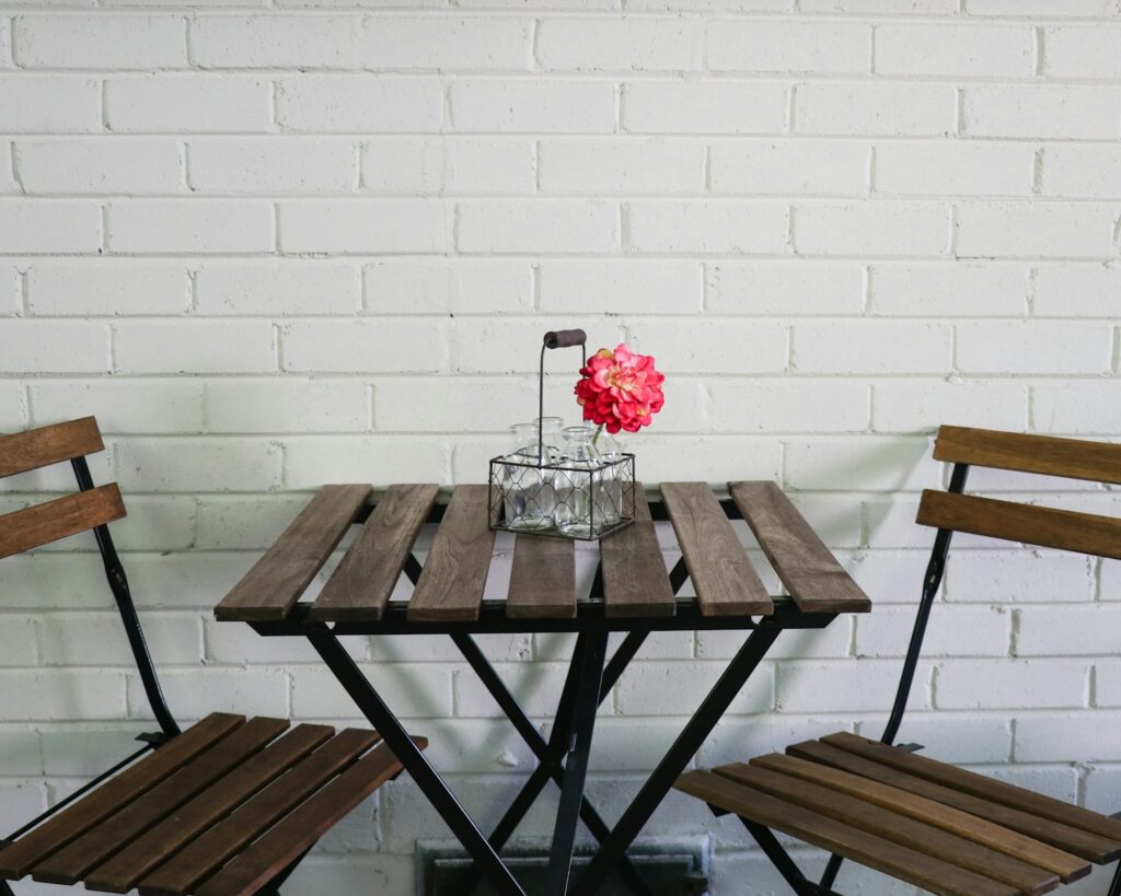 brown folding table and chairs by the white wall